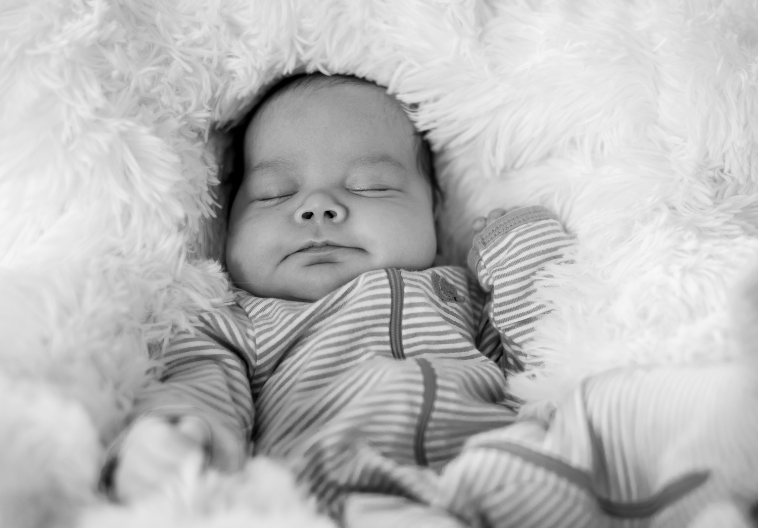 Black and white family photos. Infant sleeping on a thick puffy blanket.