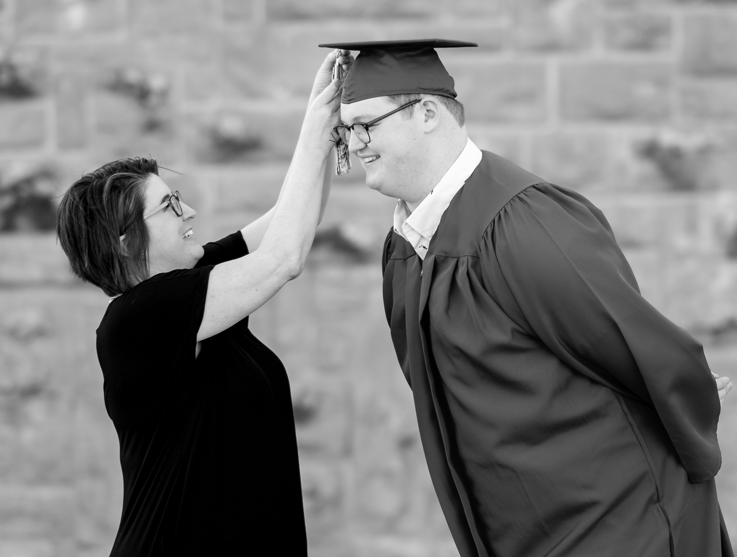 Black and white family photos. A mother adjusting the tassel on her son's graduation cap.